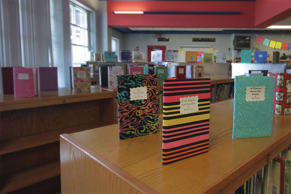 Books written by students sit on display in the library.