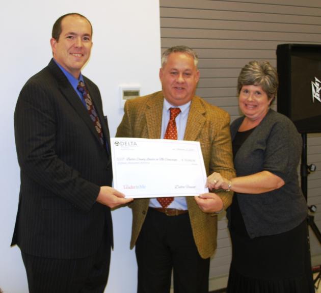Delta Faucet's Tom Pogue and Teresa Montogmery presenting Scott Howard with a check for $15,000 for the Leader In Me Program.