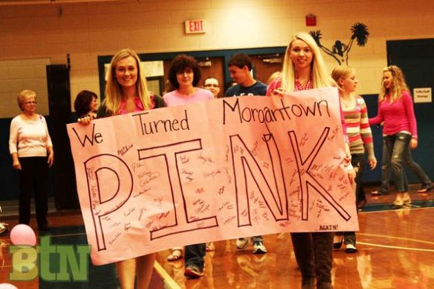 Audrey Porter and Sierra Fields carry the PINK banner.