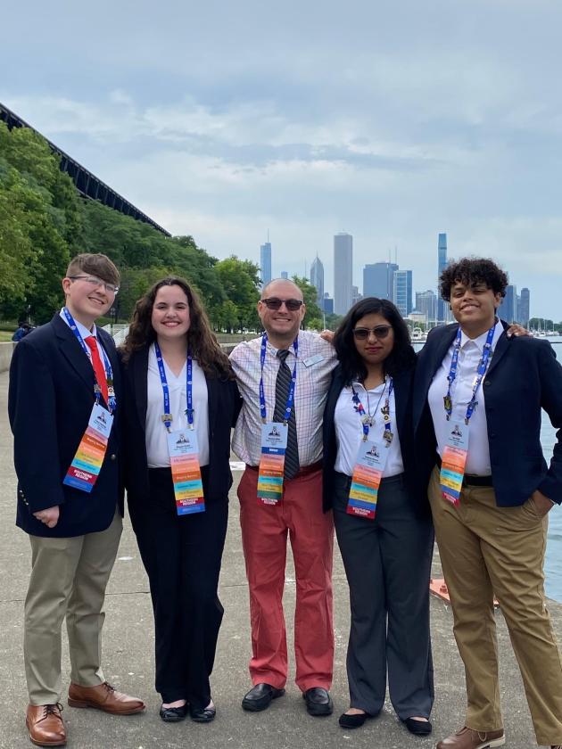 (Left to right) Parker Stallings, Maggie Drake, Thomas Miller, Sophia Burns, Aer Sells take a picture beside Lake Michigan backed by the Chicago skyline.