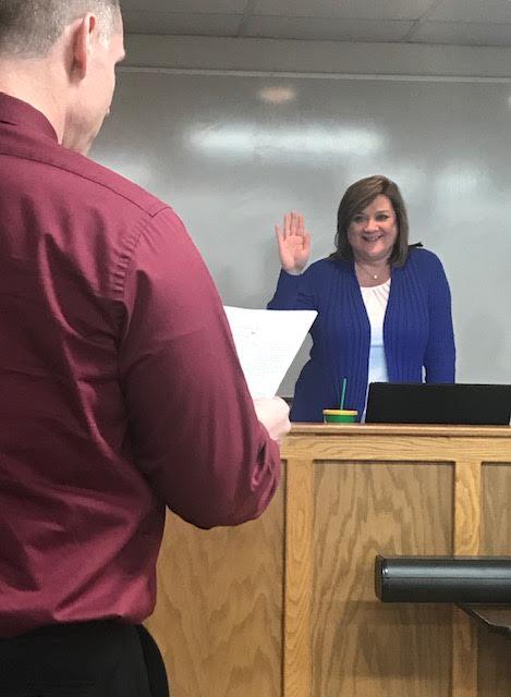 Assistant Superintendent Robert Tuck administers the Oath of Office to newly-reelected Board member Amy Hood