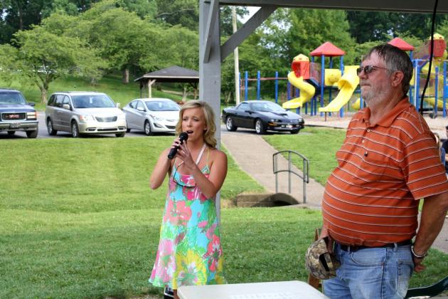 Hannah Renfrow performs the National Anthem to kick-off the 2015 Catfish Festival.  At right is Randell Gaskey, Chamber of Commerce vice-president