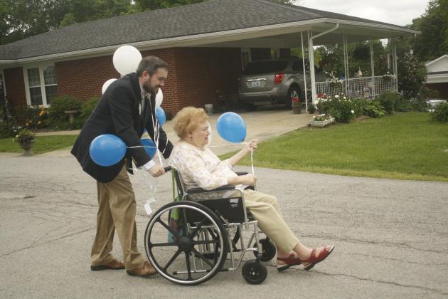 Morgantown Care and Rehabilitation Center Chaplain Derek Cain and an elder prepare to release balloons Thursday.