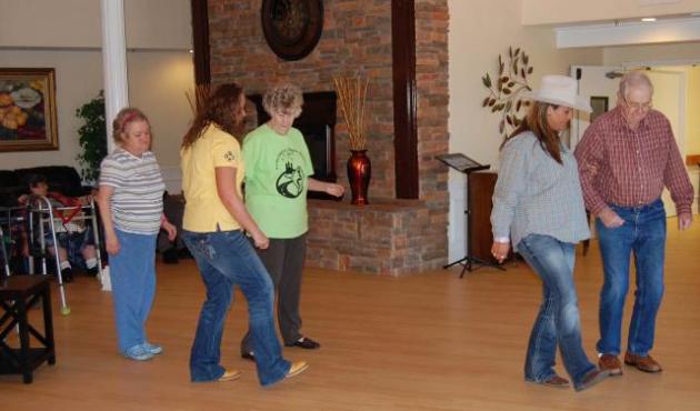 Leah Burden and Ashley Flint (foreground) teach a new dance step to Linda Gray, 