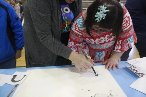 A student participates in the chinese brush painting booth during the Butler County Middle School Springs Arts Fair Friday morning. 