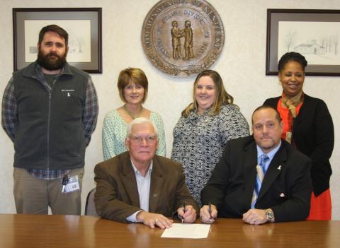 Jonathan Beville, Michaelle Johnson, Sarah Duncan and Wanda Nevins looks on as Judge David Fields and Mayor Billy Phelps signs the proclamation.