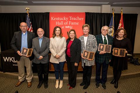 The 2023 class of the Kentucky Teacher Hall of Fame was inducted Friday at WKU. From left: Accepting for the late Helen Russell, her sons Eddie and Rick Russell; Lieutenant Governor Jacqueline Coleman; Robin Fields Kinney, Interim Commissioner of Education; accepting for the late Donna Smith, her sister Sue Holder; Jesse Brown; and Kimberlea Embry. (WKU photo by Clinton Lewis) 
