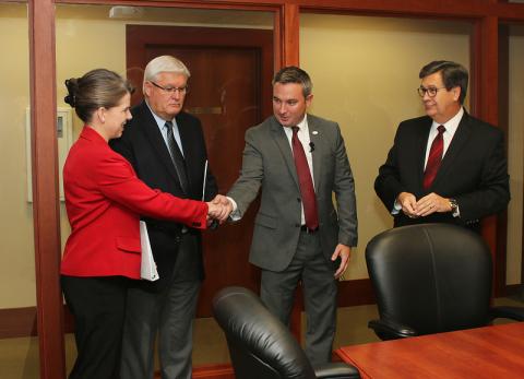  Ryan Quarles (right center) and Jean-Marie Lawson Spann (left) shook hands before David S. Beck, Executive Vice President for KFB Federation (right), and Mark Haney, KFB President (left center), conducted the coin toss to determine who spoke first at the “Measure the Candidates” forum for Kentucky Agriculture Commissioner.