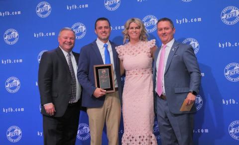 Chuck Osborne, KFB Insurance Vice President of Agency Support & Marketing (left), and Ken Wilson, KFB Insurance Director of Agency Support & Marketing (right), present Bobby Smith (center left), accompanied by his wife, Ashley (center right), with the 2021 District Two Agency Manager of the Year Award.