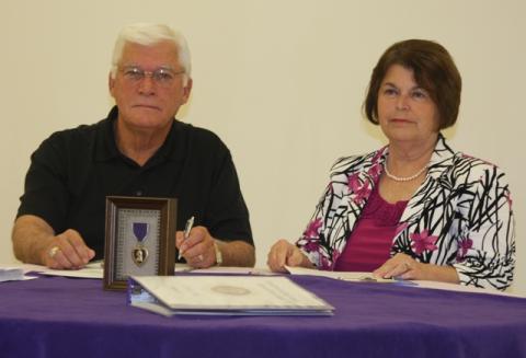 Butler County Judge David Fields and Mayor Linda Keown sign proclamations declaring Morgantown and Butler County Purple Heart communities.