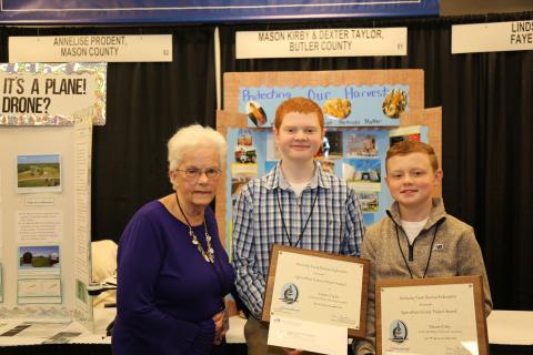   Mary Jayne Cannon of the Kentucky Farm Bureau State Women’s Committee presents Dexter Taylor and Mason Kirby an award of recognition for participation in the 2023 Science in Agriculture program.