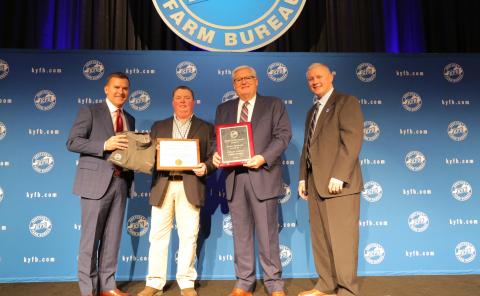  Shane Wells, President of Butler County Farm Bureau (center left), accepts the award from John Sparrow, Executive Vice President and CEO of KFB Insurance (left), Mark Haney, President of Kentucky Farm Bureau (center right), and Drew Graham, Executive Vice President of the KFB Federation (right), during a Dec. 6 recognition and awards program.