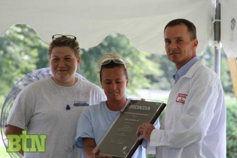 Corvac employees Dana Gill and Tiffany Flener accepts the award from Mark VanDeVelde of Honda.