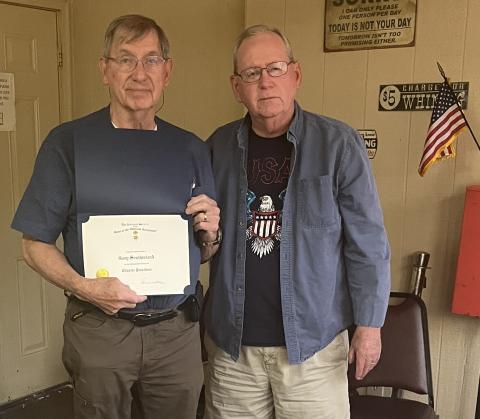 Past president Gary Southerland receives a certificate and lapel pin from chapter president Donnie Webster.   