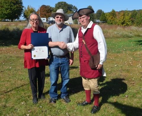 Donnie Webster presents the certificate to the Deborah and Roger Givens.