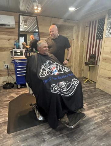 Michael Elmore with one of his customers at the "Dam Barbershop" (photo from Facebook)