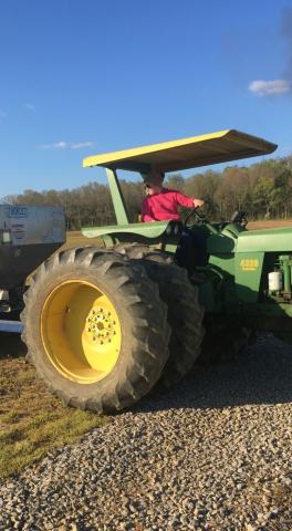 Maggie Drake spreads fertilize during the spring of 2021