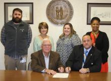 Jonathan Beville, Michaelle Johnson, Sarah Duncan and Wanda Nevins looks on as Judge David Fields and Mayor Billy Phelps signs the proclamation.