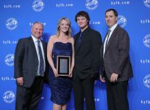  Chuck Osborne, KFB Insurance Vice President of Agency Support & Marketing (left), and Holt Hathcock, KFB Insurance Agency Support & Marketing Manager for District Two (right), present Lilly Moore Norris (center left), accompanied by her husband, Dylan Norris, with the 2022 District Two Agent of the Year Award.