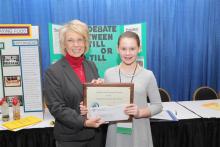 Vicki Bryant of the Kentucky Farm Bureau State Women’s Committee presents Harmony Taylor an award of recognition for her participation in the 2019 Science in Agriculture program.