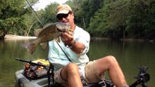 Former “Kentucky Afield” television host Tim Farmer holds a fat smallmouth bass caught from central Kentucky’s Elkhorn Creek on a topwater popper lure early last fall. The topwater, or surface, bite for stream smallmouth bass is heading toward its peak over the next few weeks. 