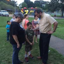  A student is prayed for by Rev. Derek Cain, the pastor at Salem Baptist Church and Rev. Ruth Morgan pastor at Mtown Naz.