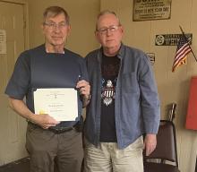 Past president Gary Southerland receives a certificate and lapel pin from chapter president Donnie Webster.   