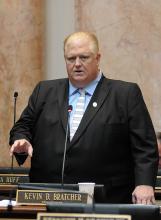 A photo from Tuesday’s proceedings in the Kentucky House of Representatives can be found here. It shows Rep. Kevin D. Bratcher, R-Louisville, presenting House Bill 63 on the House floor. 