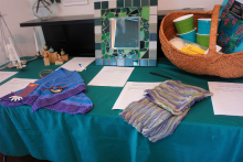 From top left: tin chandelier, tiny painted gourds, hand tiled mirror, vintage picnic basket with picnic supplies. Bottom row:  hand spun and knit shawlette with fox shape pin, Tunisian crochet kitchen towel set. These were just a few of the goodies waiting for bids.