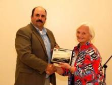 County Extension Agent Greg Drake II presents Betty Farris with an award for Reedyville RD.