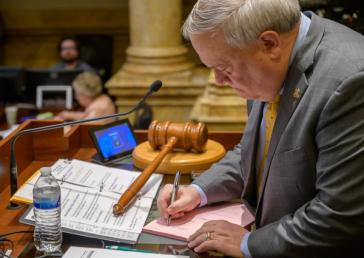 Senate President Robert Stivers, R-Manchester, signs a bill on the Senate floor Friday. 